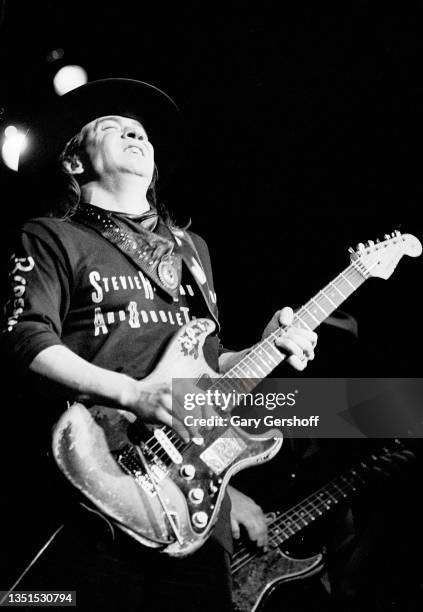 American Blues and Rock musician Stevie Ray Vaughan plays guitar as he performs onstage, with his band Double Trouble, during the 'Texas Flood' tour...