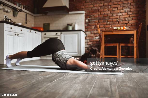 mujer haciendo ejercicios de estiramiento en casa en la cocina doméstica - mujer seductora fotografías e imágenes de stock