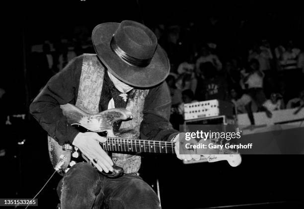 American Blues and Rock musician Stevie Ray Vaughan plays guitar as he performs onstage, with his band Double Trouble, during 'The Fire Meets the...