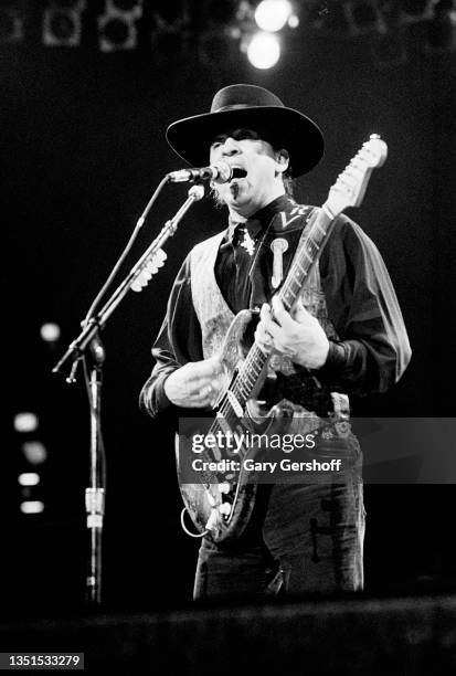 American Blues and Rock musician Stevie Ray Vaughan plays guitar as he performs onstage, with his band Double Trouble, during 'The Fire Meets the...