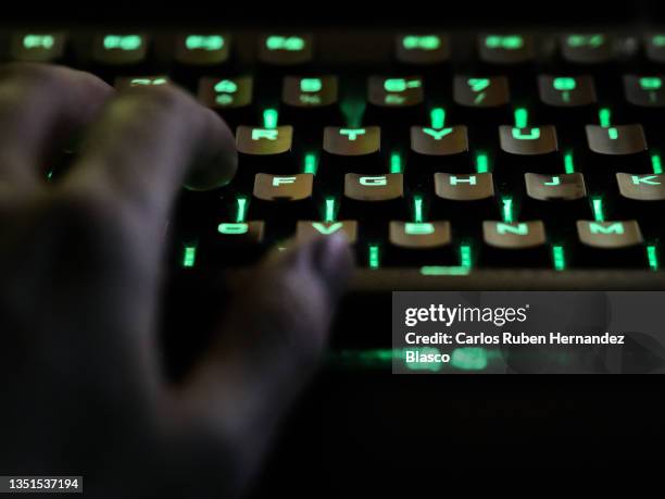 man's hand using rgb keyboard while live streaming - press night imagens e fotografias de stock