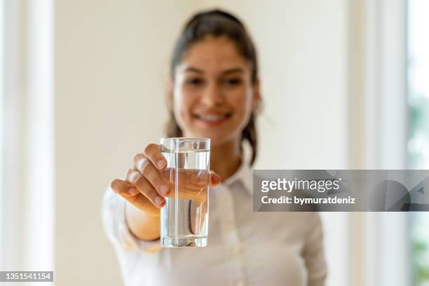 young girl holding glass of water - sparkling water glass stockfoto's en -beelden