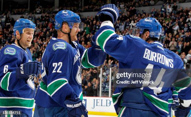 Sami Salo and Alex Burrows congratulate Daniel Sedin of the Vancouver Canucks after his third goal against the Colorado Avalanche during an NHL game...