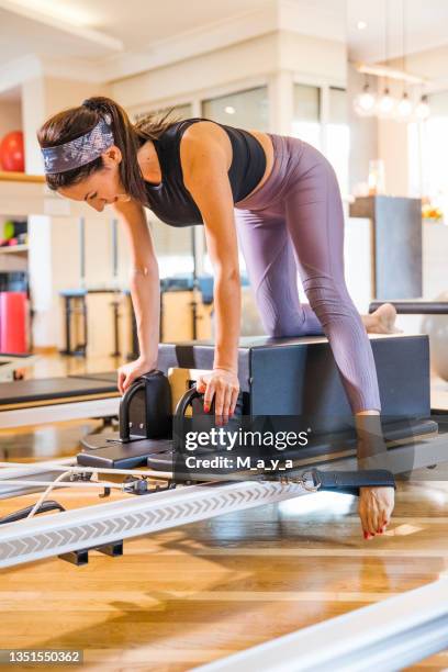 woman performing the pilates exercise - reformer stock pictures, royalty-free photos & images