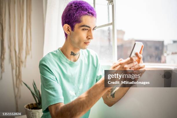 young man using mobile phone - hair colour stock pictures, royalty-free photos & images