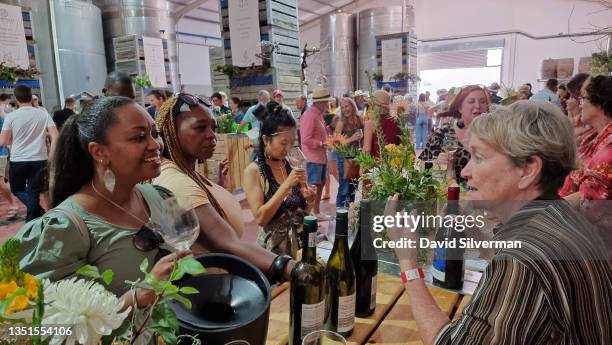 People fill the cellar hall during the Noble Vice Farm Feast wine festival on October 31, 2021 at the Kaapzicht wine estate near Stellenbosch in...