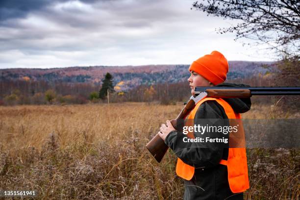 a young pheasant hunter in an autumn landscape - jager stockfoto's en -beelden