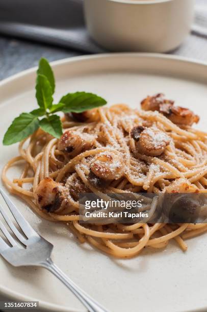 scallop pasta dish garnished with basil leaves - seared stock pictures, royalty-free photos & images
