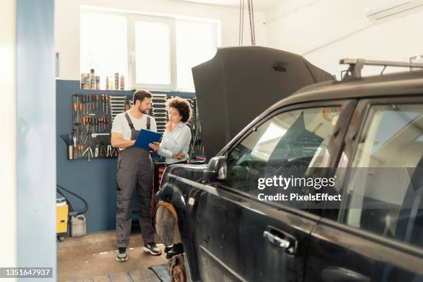 explaining the vehicle diagnosis to his customer - modern car workshop stock pictures, royalty-free photos & images