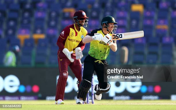 David Warner of Australia plays a shot as Nicholas Pooran of West Indies keeps during the ICC Men's T20 World Cup match between Australia and Windies...