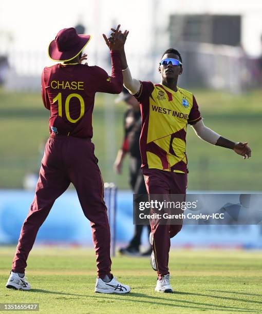 Akeal Hosein of West Indies celebrates the wicket of Aaron Finch of Australia with team mate Roston Chase during the ICC Men's T20 World Cup match...