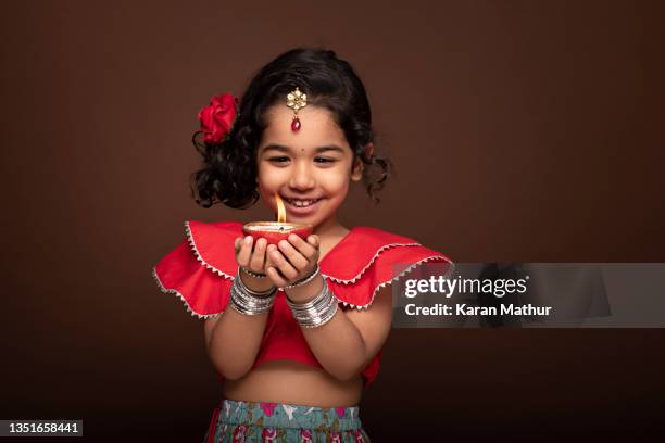 kid holding diya stockfoto - diwali stock-fotos und bilder