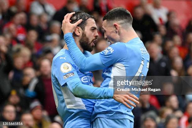 Bernardo Silva celebrates with Phil Foden of Manchester City after scoring their team's second goal during the Premier League match between...