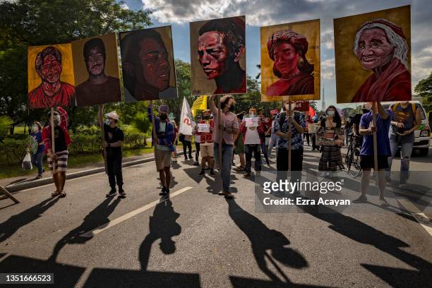 Climate activists hold up portraits of slain Philippine environmental defenders as they take part in a Global Day of Action for Climate Justice...