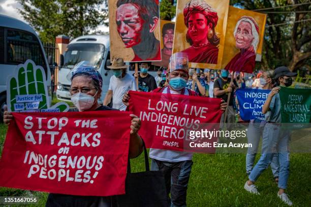 Climate activists hold up signs next to portraits of slain Philippine environmental defenders as they take part in a Global Day of Action for Climate...