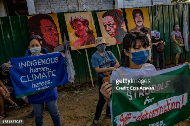 Climate activists hold up signs next to portraits of slain Philippine environmental defenders as they take part in a Global Day of Action for Climate...