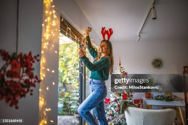 mujer joven decorando el hogar para las próximas fiestas - interiorismo fotografías e imágenes de stock