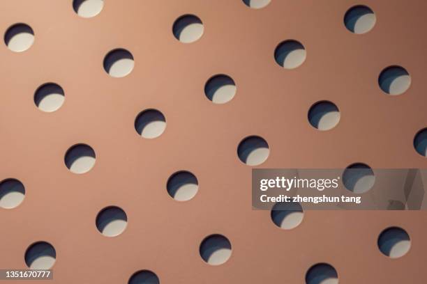 a metal plate with regular round holes. - aushöhlung stock-fotos und bilder