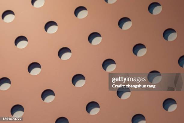 a metal plate with regular round holes. - sphere grid stock pictures, royalty-free photos & images