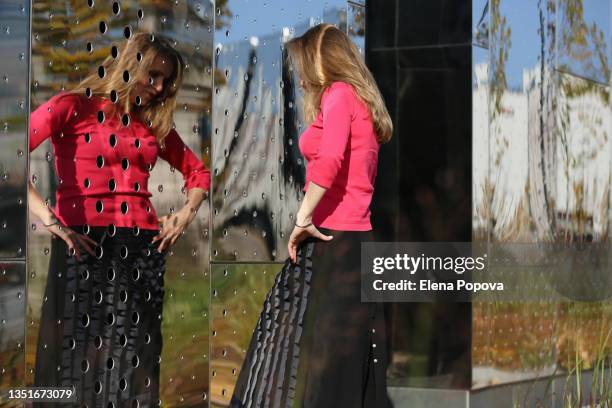 young confidence woman looking at the street mirror - woman-looking-into-mirror-full-body stock pictures, royalty-free photos & images