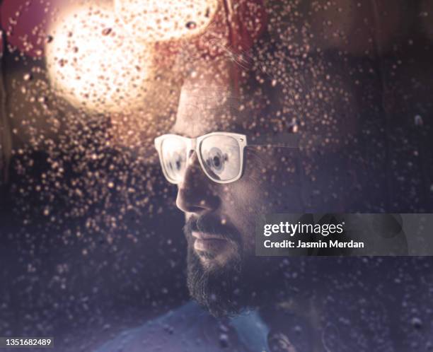 portrait of man on rain night window - bad weather on window stock pictures, royalty-free photos & images