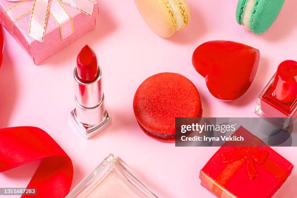 the concept of preparing for a holiday or gifts is made from beauty products for a woman, gift box and french macaroons or macarons. - heart box ribbon stockfoto's en -beelden