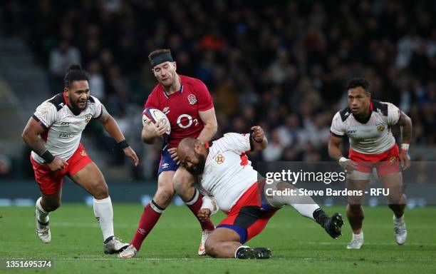 Mark Atkinson of England is tackled by Loni Uhila of Tonga during the Autumn Nations Series match between England and Tonga at Twickenham Stadium on...