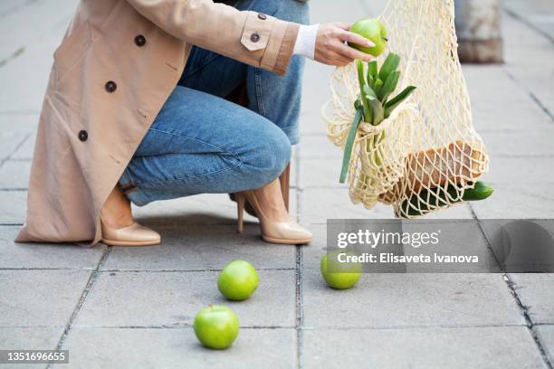 young woman dropping groceries on sidewalk - parte inferior imagens e fotografias de stock