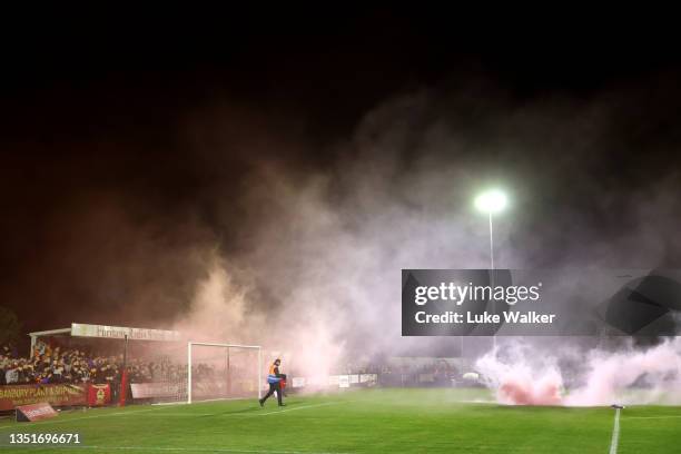 Flares are thrown onto the field of play during the Emirates FA Cup First Round match between Banbury United and Barrow at Spencer Stadium on...