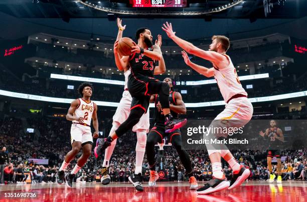Fred VanVleet of the Toronto Raptors passes the ball off against Dean Wade of the Cleveland Cavaliers during the first half of their basketball game...
