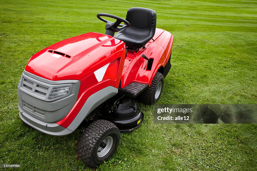 Red riding mower parked on the grass