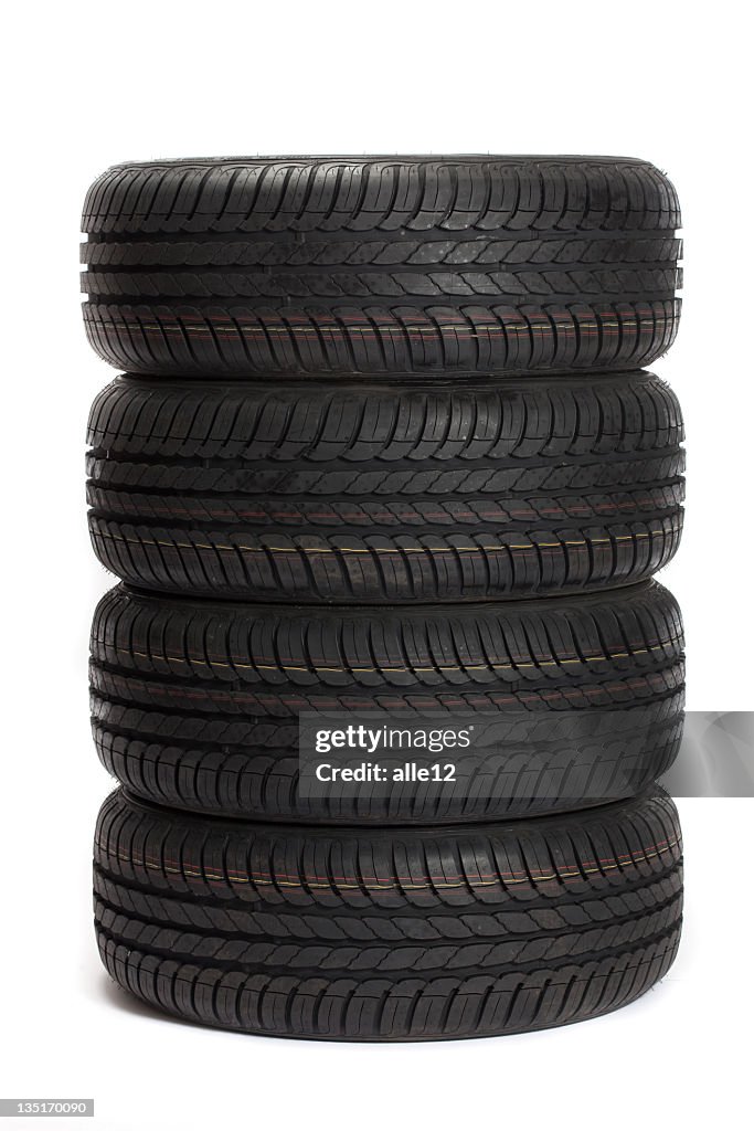 Four black car tires stacked on top of one another