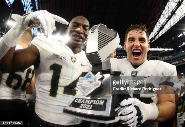 Michael Roberts and Mason Kolinchak of the Army Black Knights hold the trophy afte thte win over the Air Force Falcons at Globe Life Field on...