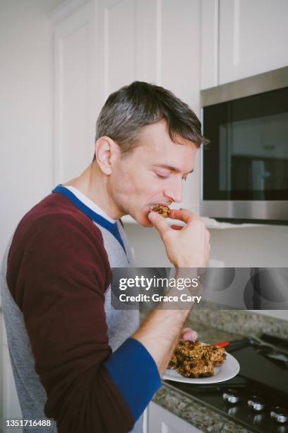 man enjoys freshly baked banana oatmeal chocolate chip cookie - chocolate chip 個照片及圖片檔