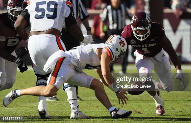Bo Nix of the Auburn Tigers has the ball knocked lose as Aaron Hansford of the Texas A&M Aggies looks to recover in the first half at Kyle Field on...