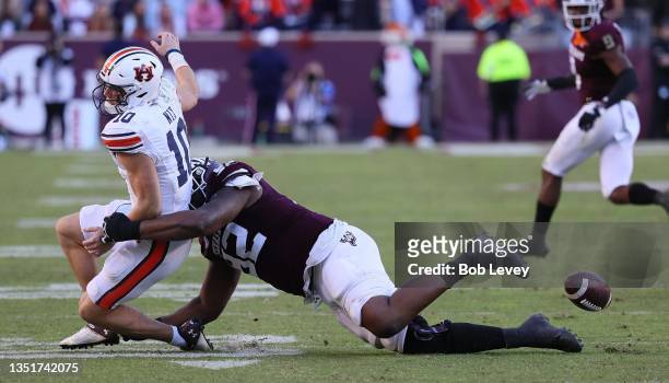 Bo Nix of the Auburn Tigers loses the ball as Jayden Peevy of the Texas A&M Aggies tackles him from behind in the fourth quarter at Kyle Field on...