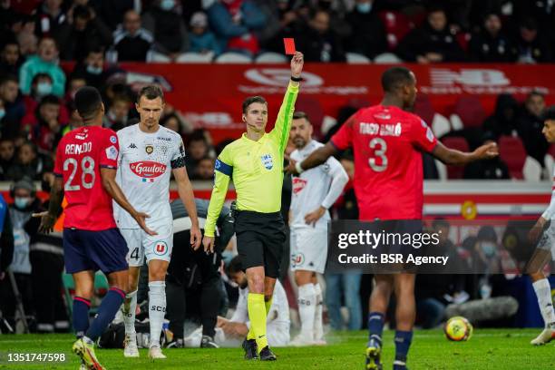 Referee Francois Letexier gives a red card to Amadou Onana of Lille OSC during the Ligue 1 Uber Eats match between Lille OSC and Angers SCO at Stade...