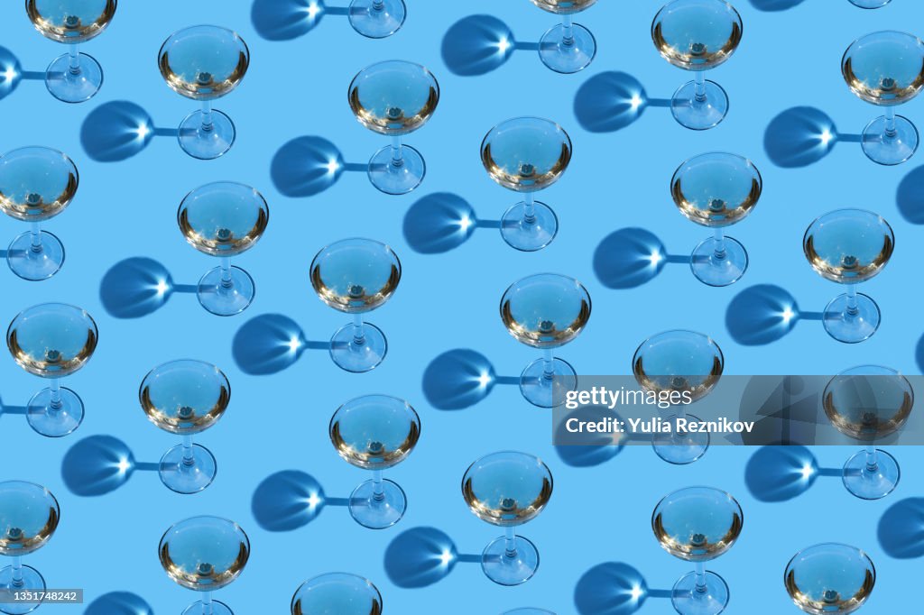 Top view of repeated champagne in glasses on the blue background