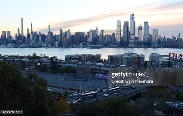 Vehicles drive on the helix ramp to the Lincoln Tunnel as the sun rises behind midtown and Hudson Yards in New York City on November 4 in Weehawken,...