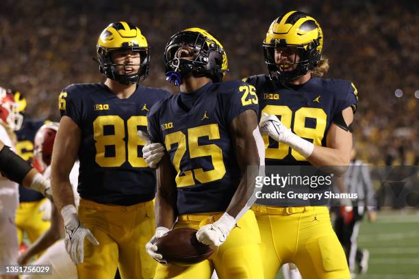 Hassan Haskins of the Michigan Wolverines celebrates a first half touchdown with Luke Schoonmaker and Carter Selzer while playing the Indiana...