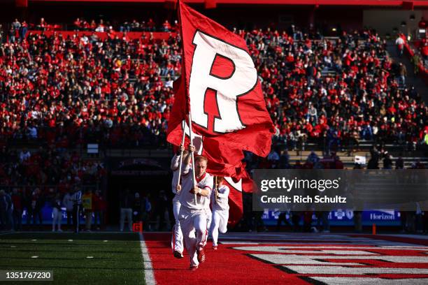 Rutgers Scarlet Knights cheerleaders run through the end zone with flags after a field goal against the Wisconsin Badgers during a game at SHI...