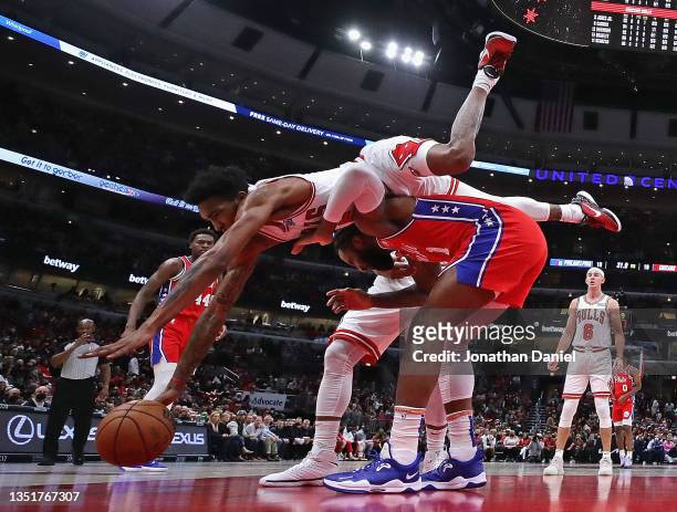 Derrick Jones Jr. #5 of the Chicago Bulls falls over Andre Drummond of the Philadelphia 76ers after knocking the ball away from Drummond at the...