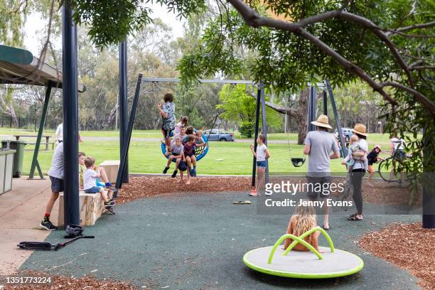 Adults look on as children play in a park in Dubbo on November 07, 2021 in Dubbo, Australia. COVID-19 travel restrictions eased on Monday 1 November...