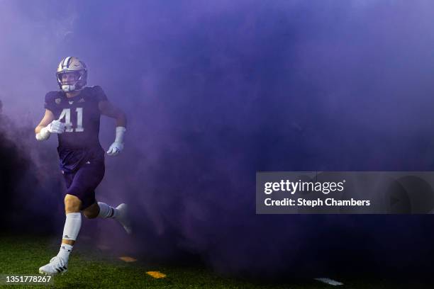 Cooper McDonald of the Washington Huskies makes his way through purple fog before the game against the Oregon Ducks at Husky Stadium on November 06,...