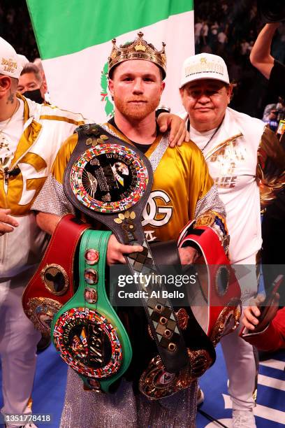 Canelo Alvarez poses with the belts after his championship bout for Alvarez's WBC, WBO and WBA super middleweight titles and Plant's IBF super...