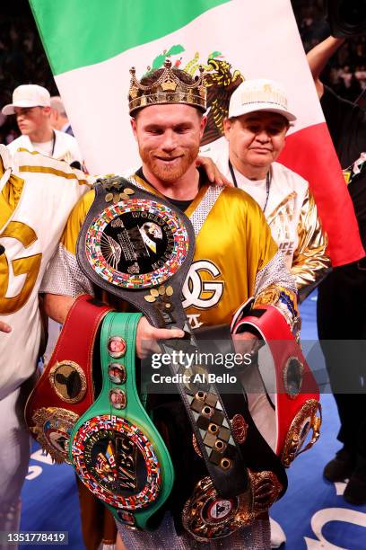 Canelo Alvarez poses with the belts after his championship bout for Alvarez's WBC, WBO and WBA super middleweight titles and Plant's IBF super...