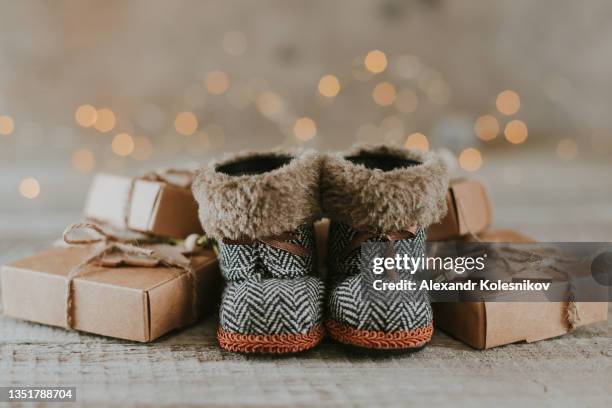 cute boots and stack of christmas gift boxes on background. - zapatos-beige fotografías e imágenes de stock