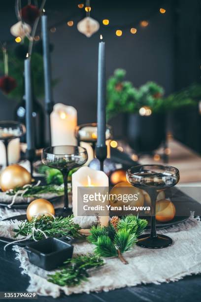 holiday table set up with candle lights, fir tree branches and christmas balls - food decoration stock-fotos und bilder