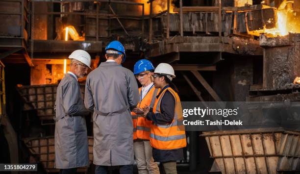 group of engineers talking about work in foundry - metaalgieter stockfoto's en -beelden