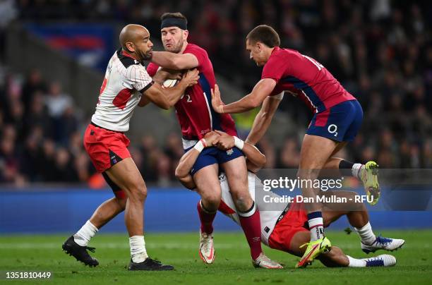 Mark Atkinson of England is tackled by Afusipa Taumoepeau and James Faiva of Tonga during the Autumn Nations Series match between England and Tonga...